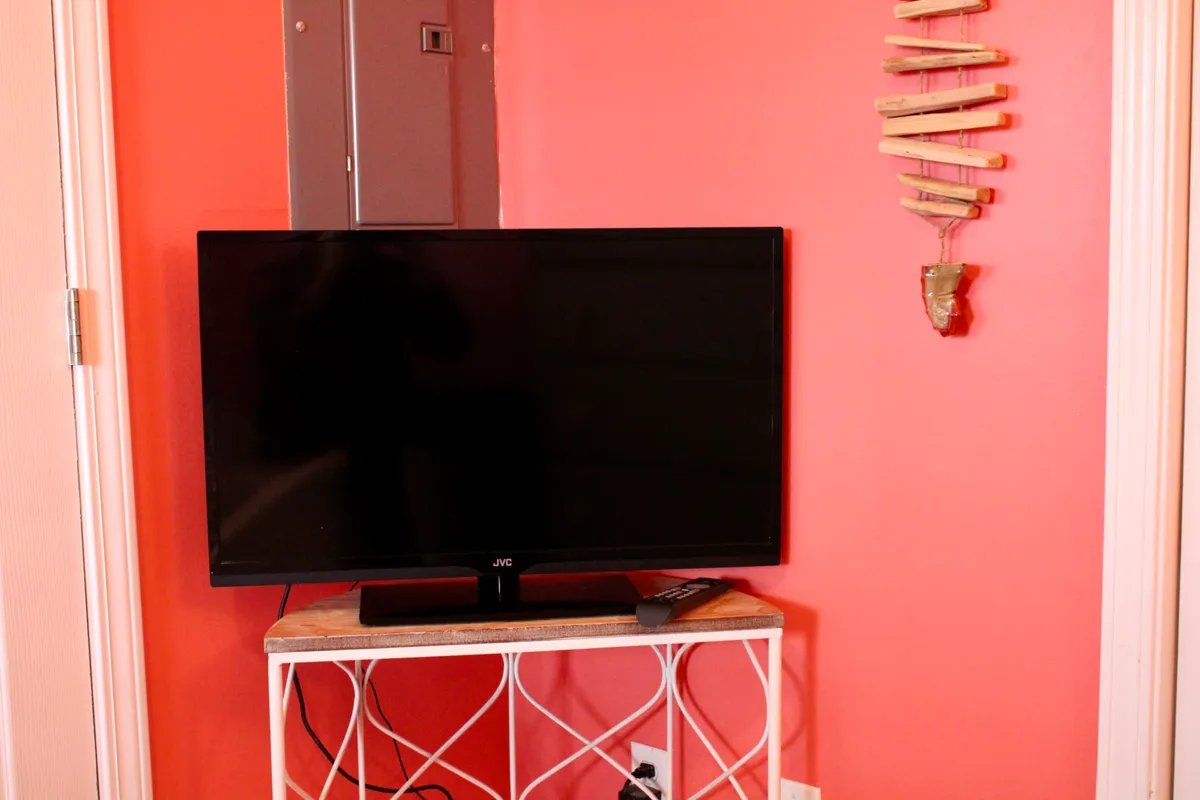 A comfortable living area featuring a TV, tasteful wall hangings, and ample seating—perfect for evening relaxation or group movie nights after exploring local nightlife. The scene is inviting and set up for socializing, echoing the idea of unwinding with friends.