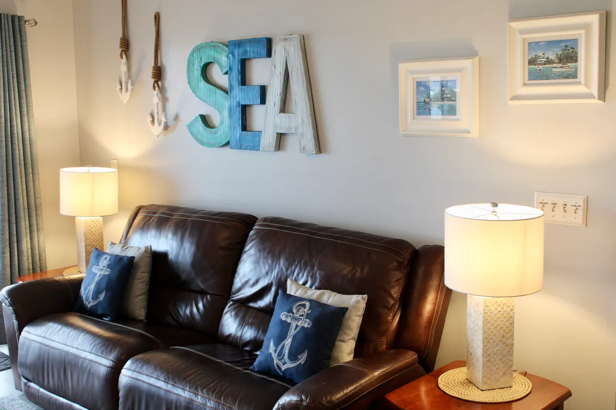 A cozy living area featuring a plush sofa with decorative pillows, soft lighting from lamps, and inviting wall art. The atmosphere is casual and relaxed, ideal for unwinding after a day of exploring or socializing with friends.